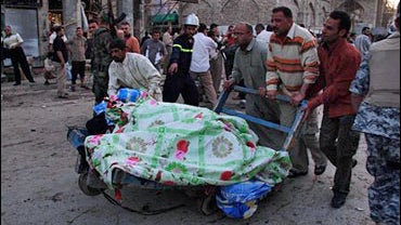 Iraqis remove the dead from the scene of suicide bombing in Karbala 