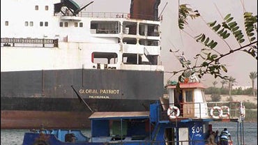 An Egyptian pilot boat guards the Global Patriot, a U.S. cargo ship which was under short term charter to the U.S. Navy's Military Sealift Command, as it sails in the Suez canal in Ismailia, Egypt, March 25, 2008. 