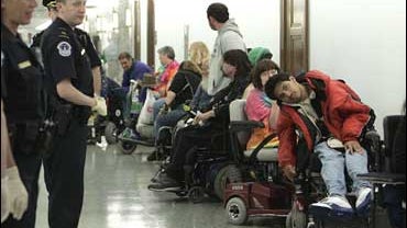 A group disabled activists, most in wheelchairs, from the group ADAPT wait to be processed after they were arrested in Washington 