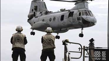 A CH-46 Sea Knight helicopter performs deck-landing qualifications aboard the amphibious dock landing ship USS Harpers Ferry 