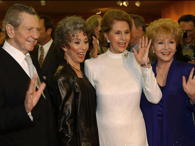 Donald O'Connor, Rita Moreno, Cyd Charisse, and Debbie Reynolds (l-r), members of original cast of movie "Singin' In The Rain", photo on black 