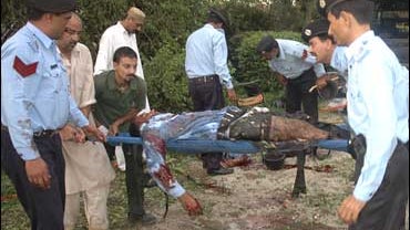 Volunteers load injured Pakistani police officers into a nearby ambulance in Islamabad 