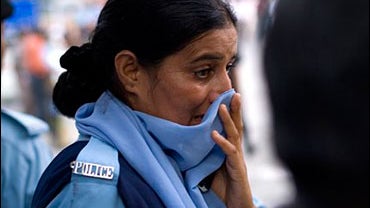 A police officer reacts at the site where a bomb exploded in Islamabad, Pakistan, Sunday July 6, 2008. A suicide attacker detonated explosives near a police station in Pakistan's capital on Sunday, killing more than 10 police officers, officials said. 