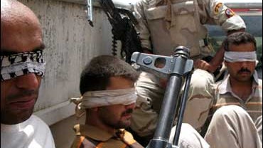 Blindfolded detainees sit in an Iraqi army vehicle in Mandali, in Iraq's Diyala province 