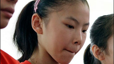 Chinese gymnast He Kexin, center, is seen with teammates at a news conference at the Samsung Pavilion at the 2008 Beijing Olympics in Beijing, Friday, Aug. 22, 2008. 