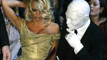 Canadian-born actress Pamela Anderson is seen with an unidentified man ahead of the Vivienne Westwood Red Label - catwalk show for London Fashion Week in central London, Thursday, Sept. 18, 2008. (AP Photo/Akira Suemori) 