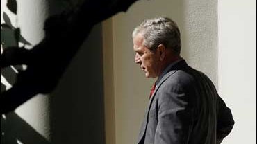 President Bush walks out of the Oval Office of the White House 