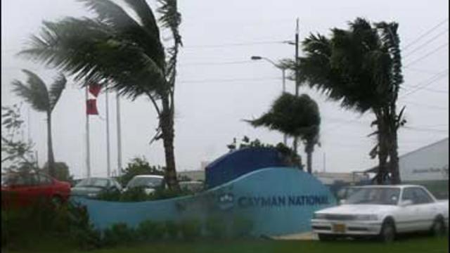 Palm trees and warning flags are blown by strong winds brought by the arrival of Hurricane Paloma in George Town, Grand Cayman 