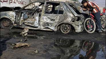 An Iraqi boy inspects a damaged car after a car bomb exploded near the Baidha secondary school in the Shiite-dominated neighborhood of Shaab in north Baghdad, Iraq on Nov. 12, 2008. 