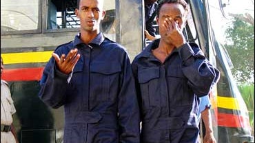 A prison warden watches Somali pirates disembark from a prison vehicle, at the law courts in Mombasa Kenya on Nov. 24, 2008, where they were brought for the Chief Magistrate to decide whether to give them bail, which they were refused. 