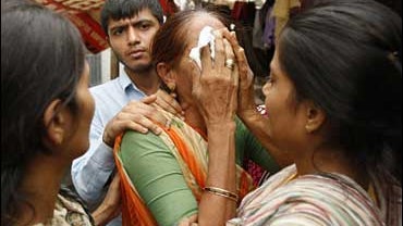 Damyanti Bhen, center, is consoled by Kalpana Paramar, left, Reena Gohil, right, and Hirendra Gohil, after she burst into tears 