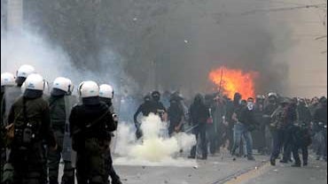 Protesters throw stones at riot police during clashes in central Athens on Sunday, Dec. 7, 2008. 