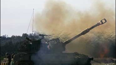 An Israeli army mobile artillery piece fires towards targets in the southern Gaza Strip 