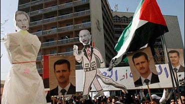 Syrian protesters, hold posters of Syrian President Bashar Assad and effigies of Israeli Foreign Minister Tzipi Livni, left, and for Israeli Prime Minister Ehud Olmert, right, during a demonstration held by the Union of the Labors' Syndicates to protest I 