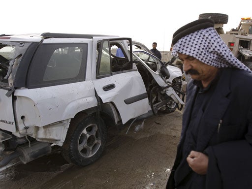 A man stands near a destroyed vehicle 