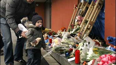 A man leads a boy to leave a stuffed animal at a memorial placed in front of the Fabeltjesland daycare center in Dendermonde, Belgium 
