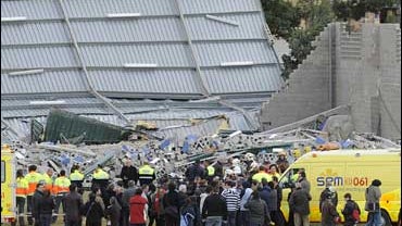 Rescuers work in part of a sports center which collapsed in high winds killing four children and trapping and injuring others in Sant Boi Llobregat, Spain 