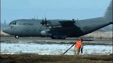 A U.S. military personnel member is seen as a transport plane taxies at the U.S. air base in Manas international airport in Kyrgyzstan 