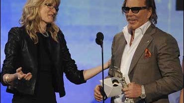 Actor Mickey Rourke, right, accepts the award for best male lead for his role in "The Wrestler" from presenter Laura Dern at the 2009 Independent Spirit Awards 