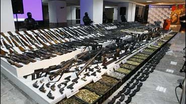 soldiers stand guard during a presentation of weapons seized during an operation against the Gulf cartel in Mexico City. 