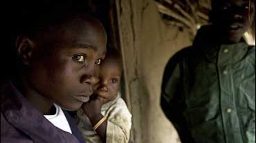 A former Mai Mai soldier holds his infant niece outside of their home in the area of Kiwanji, eastern Congo 