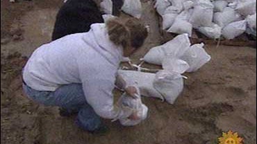 Volunteers reinforce dikes with sandbags to hold back the rising waters of the Red River, in Fargo, N.D. 