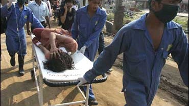Medical assistants carry an injured on a stretcher near the site of a blast in Maligaon area in Gauhati, India 