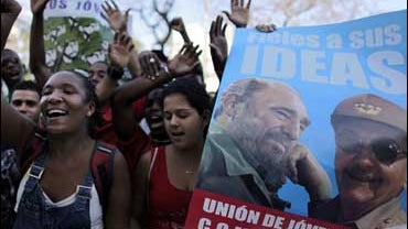 Students chant revolutionary slogans next to a image of Cuba's President Raul Castro and his brother Fidel Castro during the 48th anniversary of the triumph of Cuban forces during the 1961 Bay of Pigs invasion, in Havana 