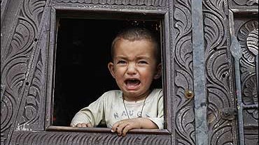 A young boy cries as he waits for his father, in a truck at a refugee camp in Mardan, in northwest Pakistan, Thursday, May 7, 2009. 