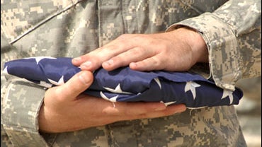 U.S. Army Sgt. Paul Slater holds a ceremonial flag during a memorial ceremony at Camp Liberty, Baghdad, Iraq, Sept. 11, 2008. 