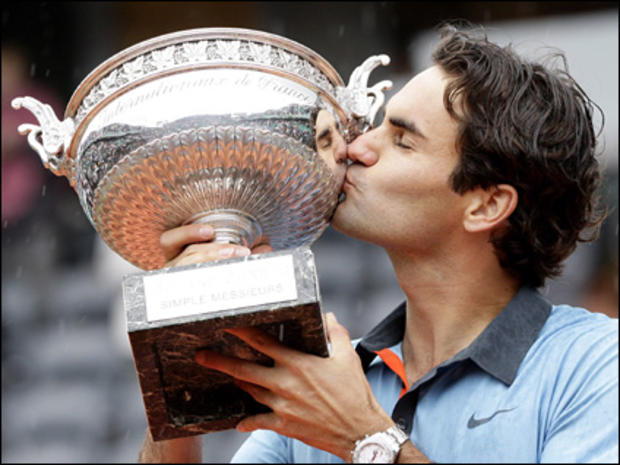 Switzerland's Roger Federer raises the trophy after defeating Sweden's Robin Soderling during their men's singles final match of the French Open tennis tournament at the Roland Garros stadium in Paris, Sunday June 7, 2009. 