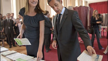 French first lady Carla Bruni-Sarkozy, left, and her husband, French President Nicolas Sarkozy, pick up ballot papers before casting their vote for the European elections, Sunday, June 7, 2009 in Paris 