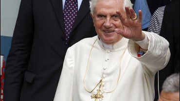 Pope Benedict XVI waves and smiles he leaves the Regional Hospital in Aosta, Italy, Friday after surgery on his right wrist. The pope broke his right wrist during a late-night fall in his Alpine vacation chalet and will have to have his arm in a cast for  
