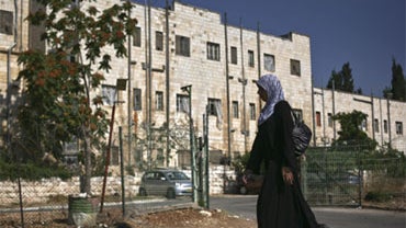 A Palestinian woman walks next to the Shepherd Hotel in East Jerusalem, Sunday, July 19. 2009. 