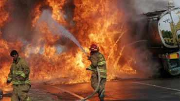 An Afghan firefighter works on a burning tanker carrying fuel for NATO forces in Afghanistan on the Jalalabad-Kabul highway, east of Kabul, Afghanistan on Saturday, August 1, 2009. 