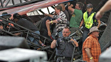 Police officers and others work to free people from the wreckage of the main stage after it flipped in a storm during the Big Valley Jamboree in Canrose, Alberta Canada on Saturday Aug. 1, 2009. 