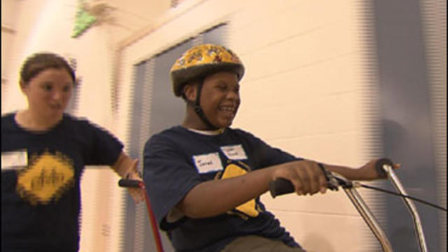 Children with autism and Down's Syndrome learn how to ride a bicycle at a camp run by researchers at the University of Michigan. 