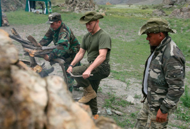 Vladimir Putin breaks a tree branch for a bonfire 