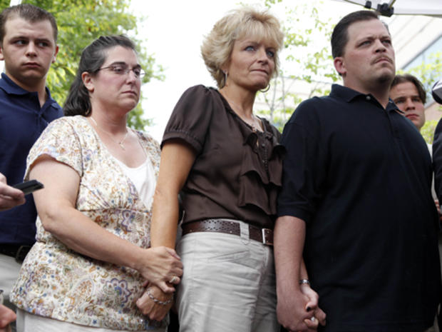 Daniel Schuler, right, holds hands with sisters-in-law Jay Schuler, center, and Joyce Schuler, left, while surrounded by reporters during a press conference in Garden City, N.Y., Thursday, Aug. 6, 2009. Schuler's wife Diane was drunk and high on marijuana 