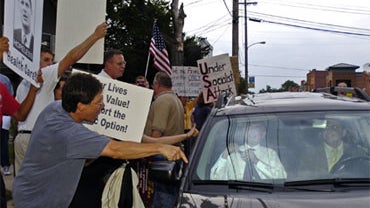 Protestors against national health care yell at Congressman Pete Visclosky as he buckles his seat-belt in his car on Claumet Road after a forum on health care held by the The Democratic Alliance of Northwest Indiana Monday, Aug. 3, 2009, at the Westcheste 