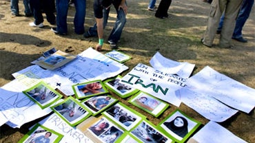 Iranian protesters stand beside placards and pictures of people, who were allegedly killed in the crackdown on opposition in their country, during a rally Saturday, July 25, 2009 in Islamabad, Pakistan. 