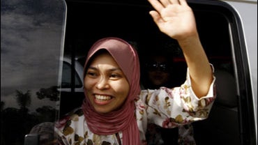 Muslim model Kartika Sari Dewi Shukarno, 32, who will be caned for drinking beer, waves farewell to her family and supporters as she is taken away by Islamic religious officers at her father's home in Karai, 200 kilometers (124 miles) north of Kuala Lumpu 