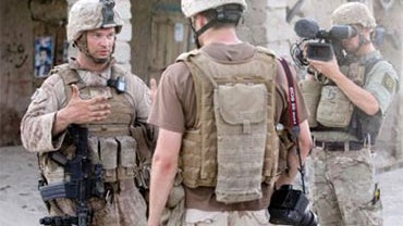 TV reporters Lucian Reed (right) and Seth Moulton interview U.S. Marine Corps Capt. Gus Biggio of 1st Battalion, 5th Marine Regiment, about cleanup plans for a bazaar in Helmand province, Afghanistan, July 19, 2009. Mouton and Reed are temporarily embedde 