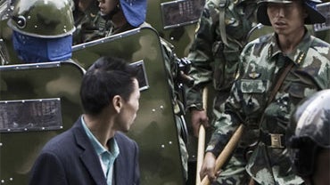 Chinese paramilitary police disperse the crowd, after the unconfirmed report of a needle attack on a boy outside the People's Square in Urumqi, Xinjiang province, China, Saturday, Sept. 5, 2009. 