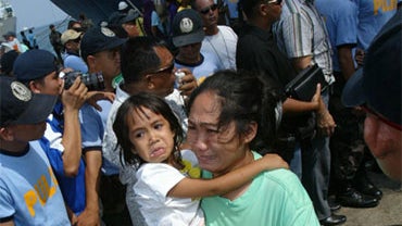 A woman and a girl passenger of the sunken "Superferry 9" arrive at the southern port city of Zamboanga, Philippines, Sunday, Sept. 6, 2009. 