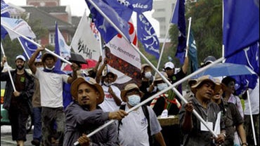 Activists wave flags and march on the street during a protest outside the U.N. regional office, where delegates are holding talks on climate change Thursday, Oct. 1, 2009 in Bangkok, Thailand. Activists and fishers from Southeast Asia blamed northern coun 
