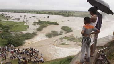 People look at an overflowing dam in Dindi, in Andhra Pradesh state, India, Oct. 1, 2009. Torrential rains destroyed hundreds of homes and caused heavy flooding in southern India. 