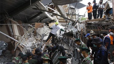 Indonesian soldier and rescue workers try to remove bodies trapped in the Ambacang Hotel Saturday, Oct. 3, 2009 in Padang, Indonesia 