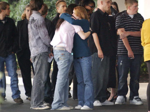 Friends and family of slain 18-year-old Melanie G. Wells quietly hug after a memorial service Friday, Sept. 25, 2009 outside Inwood, W.Va. Melanie Wells was one of the four victims in the recent Farmville, Va. deaths. (AP Photo/Journal Newspaper, Ron Agni 
