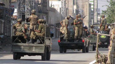 Pakistan Army troops prepare to leave for patrolling during a curfew in Bannu, a town on the edge of Pakistan's lawless tribal belt Waziristan, Saturday, Oct. 17, 2009. 
